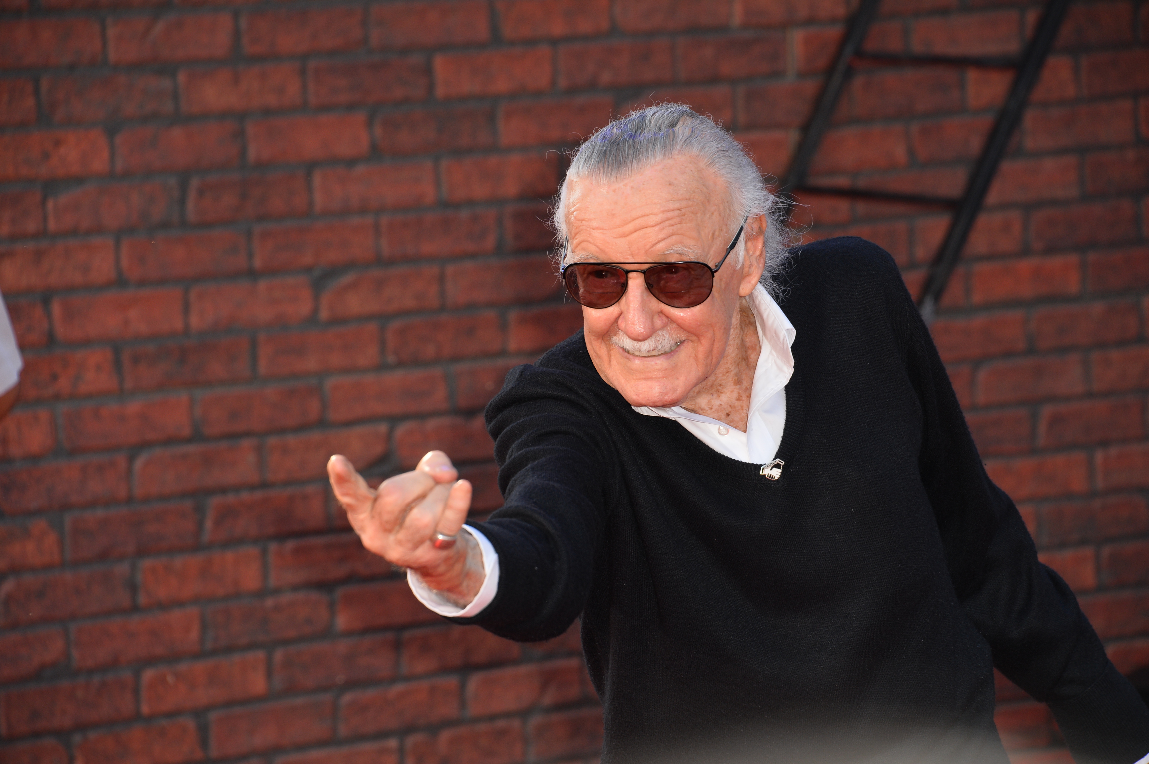 stan lee posing for photo at spiderman premier